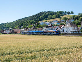 Ein Regionalzug in der Nähe von Bad Hersfeld, im Vordergrund ein Kornfeld