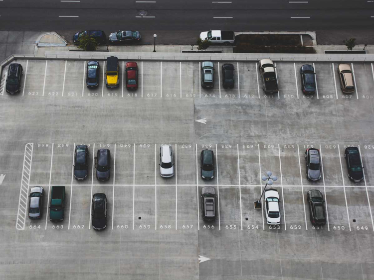 Ein grauer Parkplatz von oben.