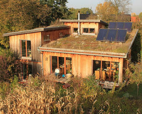 ein Haus aus Naturbaustoffen mit Solaranlage auf dem Dach