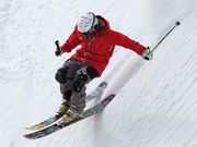 Skifahrer fährt verschneiten Hang herunter