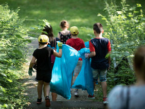 Das Bild zeigt Schulkinder beim Müllsammeln.