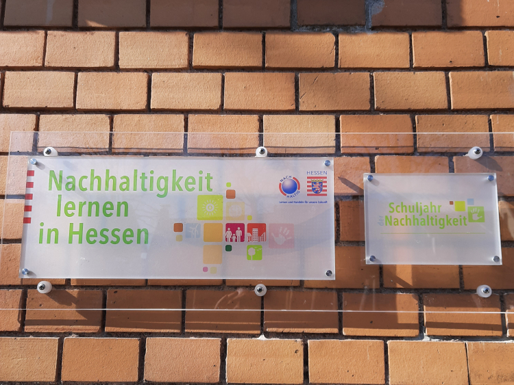 Auszeichnungen von "Nachhaltigkeit lernen in Hessen" und "Schuljahr der Nachhaltigkeit" an einer Schulfassade